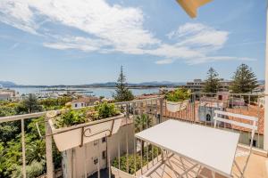 a balcony with a white table and plants on it at Antares Rooms and Suites in Olbia