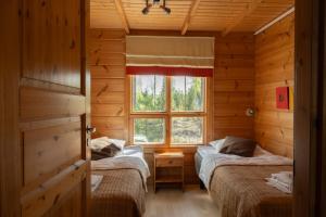 two beds in a room with a window at Oravi Villa 1 Teeri in Savonlinna