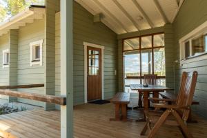 a porch of a cabin with a table and chairs at Oravi Villa 1 Teeri in Savonlinna