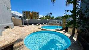 a large blue pool on a patio next to a building at Atlas Beach Hotel in Fortaleza +53 photos