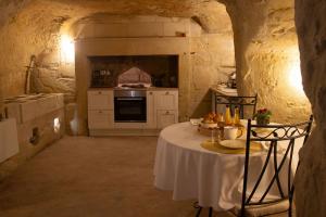 a kitchen with a table in a stone room at Lantray Secrète in Les-Trois-Moutiers