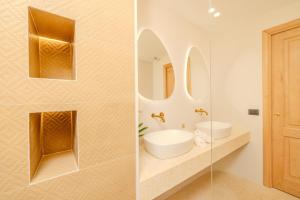 a bathroom with two sinks and two mirrors at Antares Rooms and Suites in Olbia +161 photos