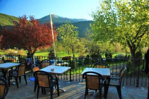 a group of tables and chairs on a patio with a view at Hotel, Bungalows y Camping Viu in Víu +30 photos