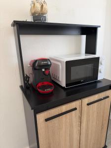 a black counter with a microwave and a blender at Le petit port de boucain in Port-de-Bouc