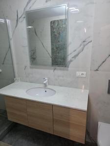 a bathroom with a sink and a mirror at Sky luxury apartment in Giurgiu