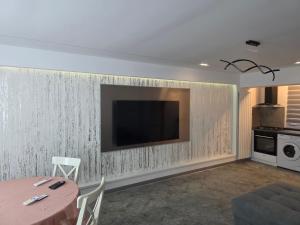 a living room with a television on a wall at Sky luxury apartment in Giurgiu +14 photos