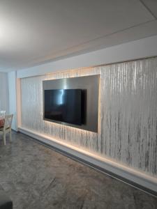 a living room with a television on a wall at Sky luxury apartment in Giurgiu