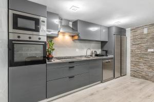 a kitchen with stainless steel appliances and a brick wall at Villa Jeronimo`s in Geres