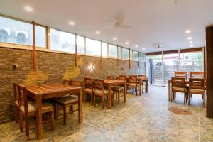 a restaurant with wooden tables and chairs and a brick wall at The Fortune Hotel, Newtown in New Town