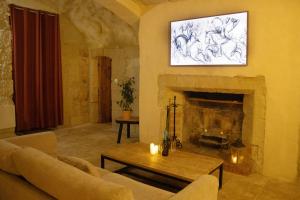 a living room with a couch and a fireplace at Lantray Secrète in Les-Trois-Moutiers