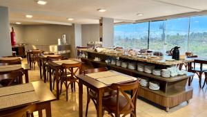 a restaurant with tables and chairs and a buffet at Atlas Beach Hotel in Fortaleza