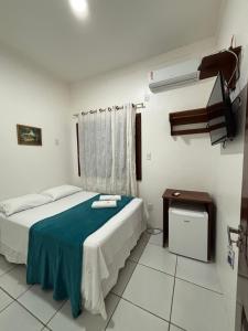 a bedroom with a bed and a table in it at Pousada Vilas Boas in Barreirinhas