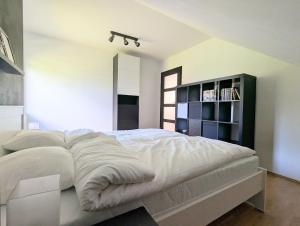 a bedroom with a large white bed with a book shelf at Ostań i Odpocznij Podzamcze in Podzamcze