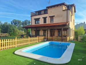 a house with a swimming pool in front of a house at Casa vacacional El Arroyo in Ferreras de Arriba
