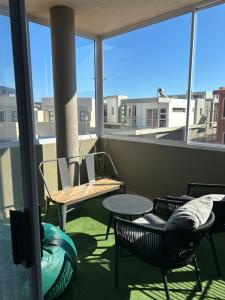 a balcony with chairs and a table and a window at Beach Hive 2 in Walvis Bay +28 photos
