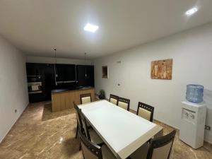 a room with a table and chairs and a kitchen at HENRI'S APARTAMENT in Durrës