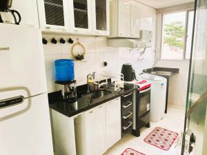 a small kitchen with a sink and a refrigerator at Apto Completo próximo Aeroporto e Shopping in Várzea Grande