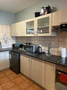 a kitchen with wooden cabinets and a microwave at Beach Hive 2 in Walvis Bay