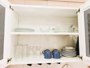 a cupboard filled with dishes and glass jars at Apto Completo próximo Aeroporto e Shopping in Várzea Grande +41 photos