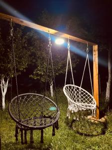 two swings in a yard at night with a light at Durmitor Hideaway in Žabljak