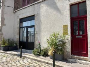 a red door on the side of a building at Quiétude au Bord de Loire. in Orléans +8 photos