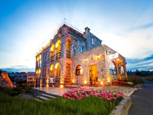 a large stone building with flowers in front of it at Ala Stone Hotel - Balloon View Experience in Göreme