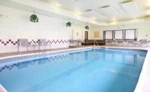 a large swimming pool with blue water in a building at SpringHill Suites by Marriott Tulsa in Union