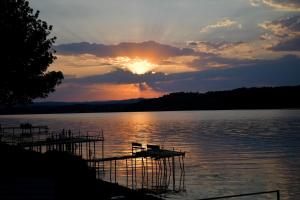 a sunset on a lake with a boat in the water at Casa Maria in Vrancea