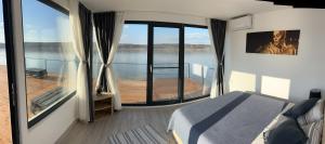 a bedroom with a balcony with a bed and a view of the water at Casa Maria in Vrancea
