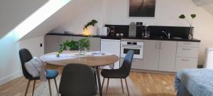 a kitchen with a table and chairs in a room at Quiétude au Bord de Loire. in Orléans