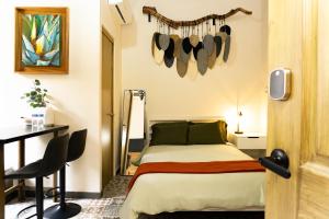 a bedroom with a bed and a table and a desk at Casa del Patio in Guadalajara