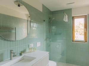 a green tiled bathroom with a sink and a mirror at Eldehaus Plau am See klimatisiert in Plau am See +52 photos