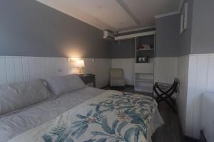 a bedroom with a bed and a couch in it at Inaki Uhi Hotel in Hanga Roa