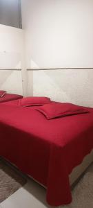 a red bed with red pillows in a bedroom at Espaço Jk in Diamantina