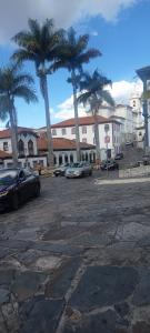 a parking lot with palm trees and parked cars at Espaço Jk in Diamantina