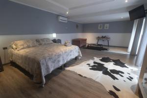 a bedroom with a large bed and a rug at Inaki Uhi Hotel in Hanga Roa