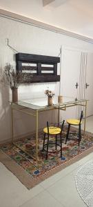 a glass table and two chairs on a rug at Espaço Jk in Diamantina