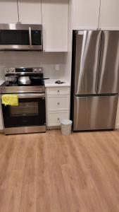 a kitchen with a stainless steel refrigerator and cabinets at Luxury Heart of the city in Surrey
