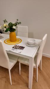 a white table with white chairs and a yellow vase at Luxury Heart of the city in Surrey +15 photos