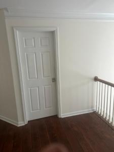 an empty room with a white door and stairs at QueenRoom1 in Ellenwood