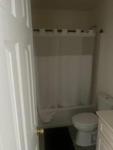 a white bathroom with a toilet and a shower at QueenRoom1 in Ellenwood