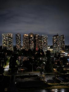a city lit up at night with tall buildings at Modern suite in Surrey