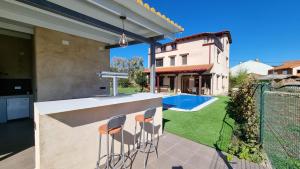 a backyard with a bar with stools at Casa vacacional El Arroyo in Ferreras de Arriba