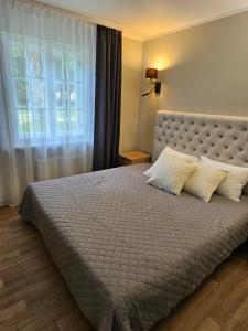 a bedroom with a large bed with a large window at B5 Jurmala Apartments in Jūrmala