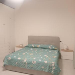 a bedroom with a bed with a green comforter at La Perla sul Trasimeno in San Feliciano