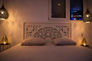 a bedroom with a large white bed with two pillows at Eaux Spa in Rouen