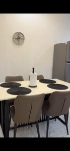 a table with chairs and a clock on the wall at Oak Serviced Apartment-New Bodija in Ibadan