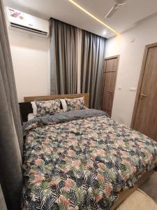 a bedroom with a large bed with a colorful comforter at La Villa K - 1 Studio in Lomé +4 photos