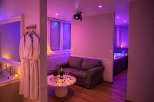 a living room with purple lighting and a couch and a table at Eaux Spa in Rouen +68 photos