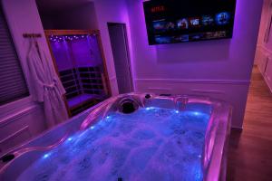 a bathroom with a tub with purple lights in it at Eaux Spa in Rouen